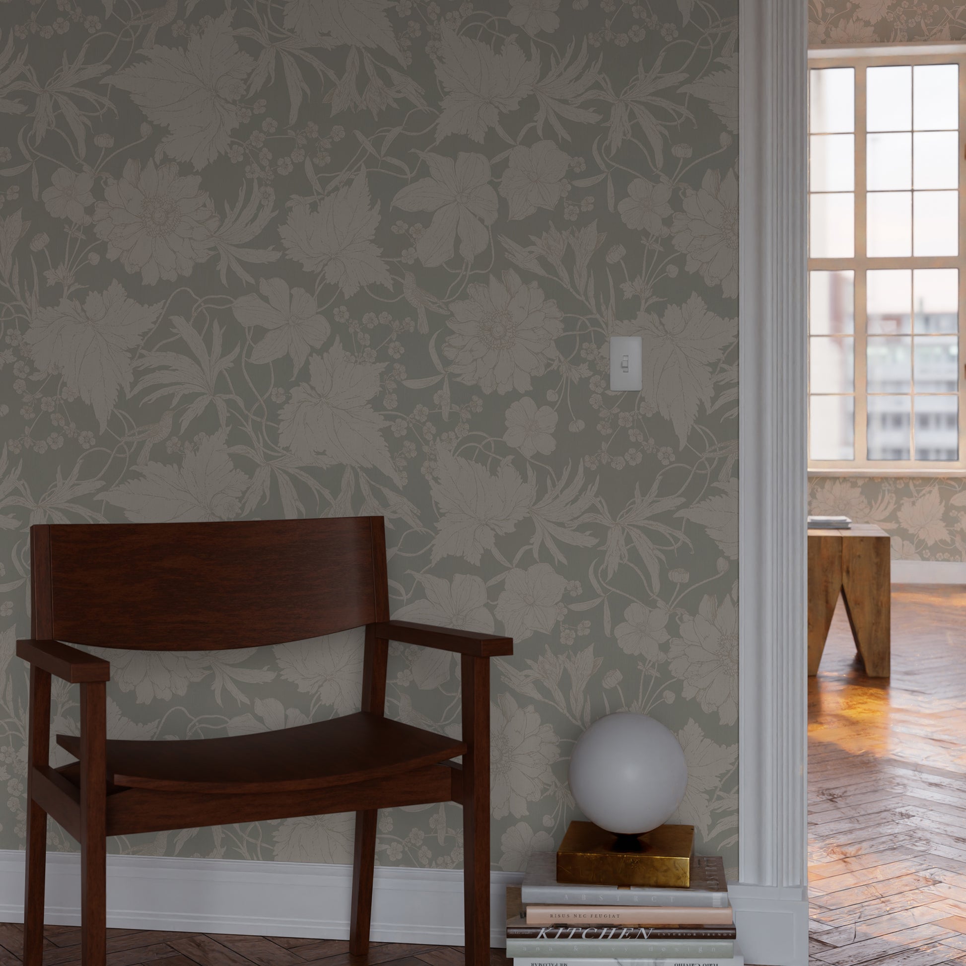 Wooden chair against a wall with a floral, sage green wallpaper with hummingbirds, white flowers and leaves.